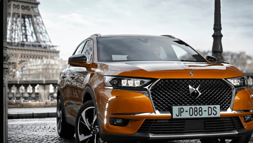 An orange DS 7 parked in front of the Eiffel Tower